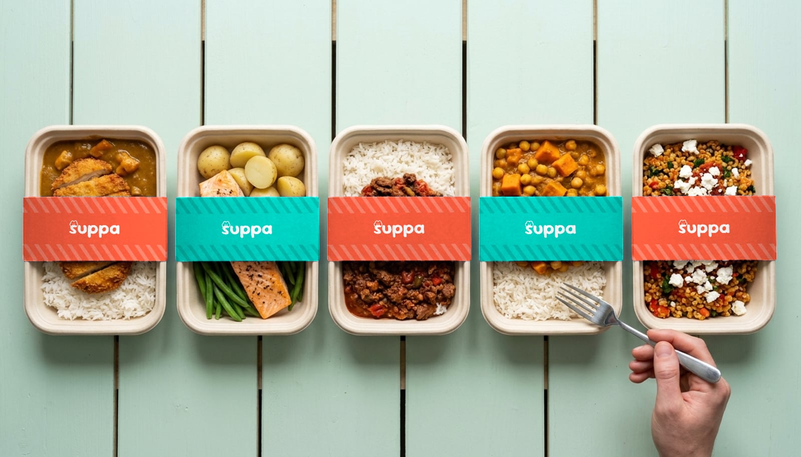 Five open Suppa meal trays on a mint table, with their teal sleeves and lids beside them